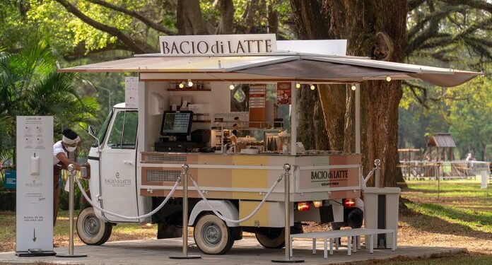 Carrinho Ape Bacio di Latte em parque com toldo e iluminação