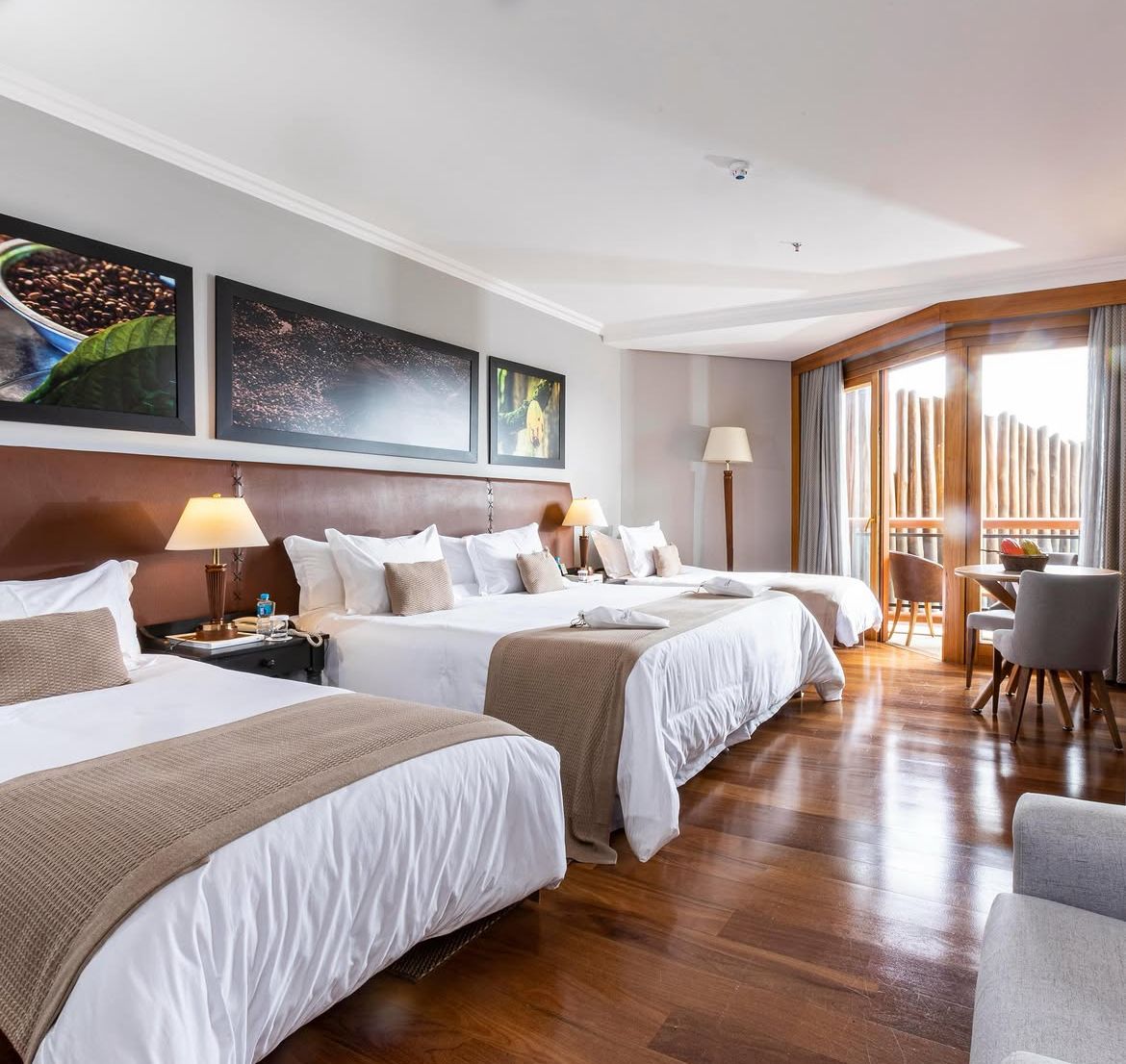 Quarto triplo com painéis fotográficos de cacau sobre cabeceira