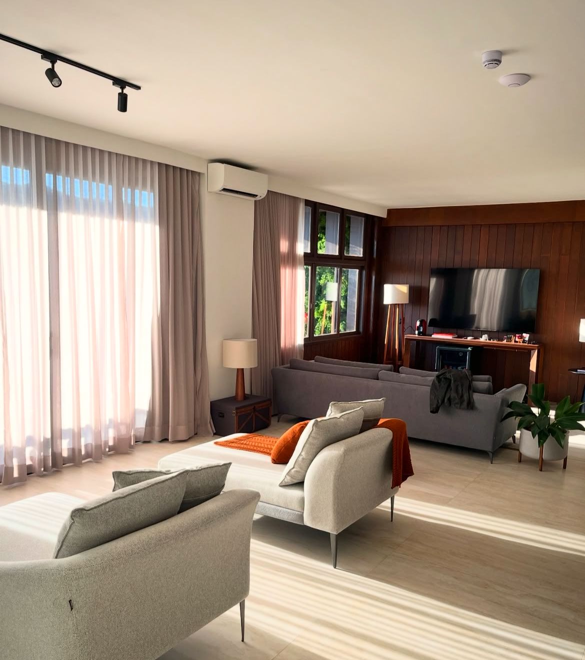 Sala de estar da suíte com sofás e cortinas