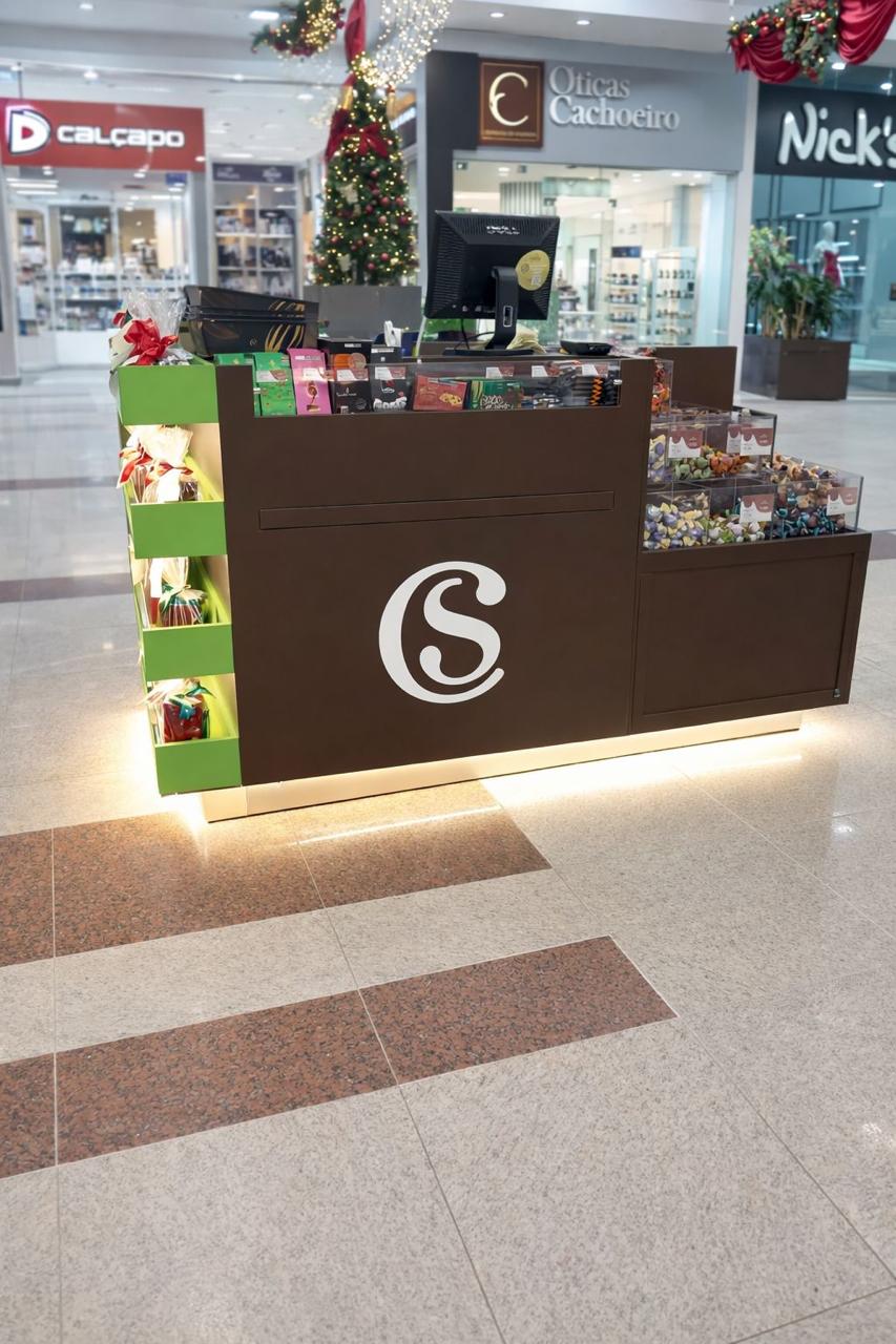 Quiosque Cacau Show em shopping com monograma branco e iluminação embutida na base
