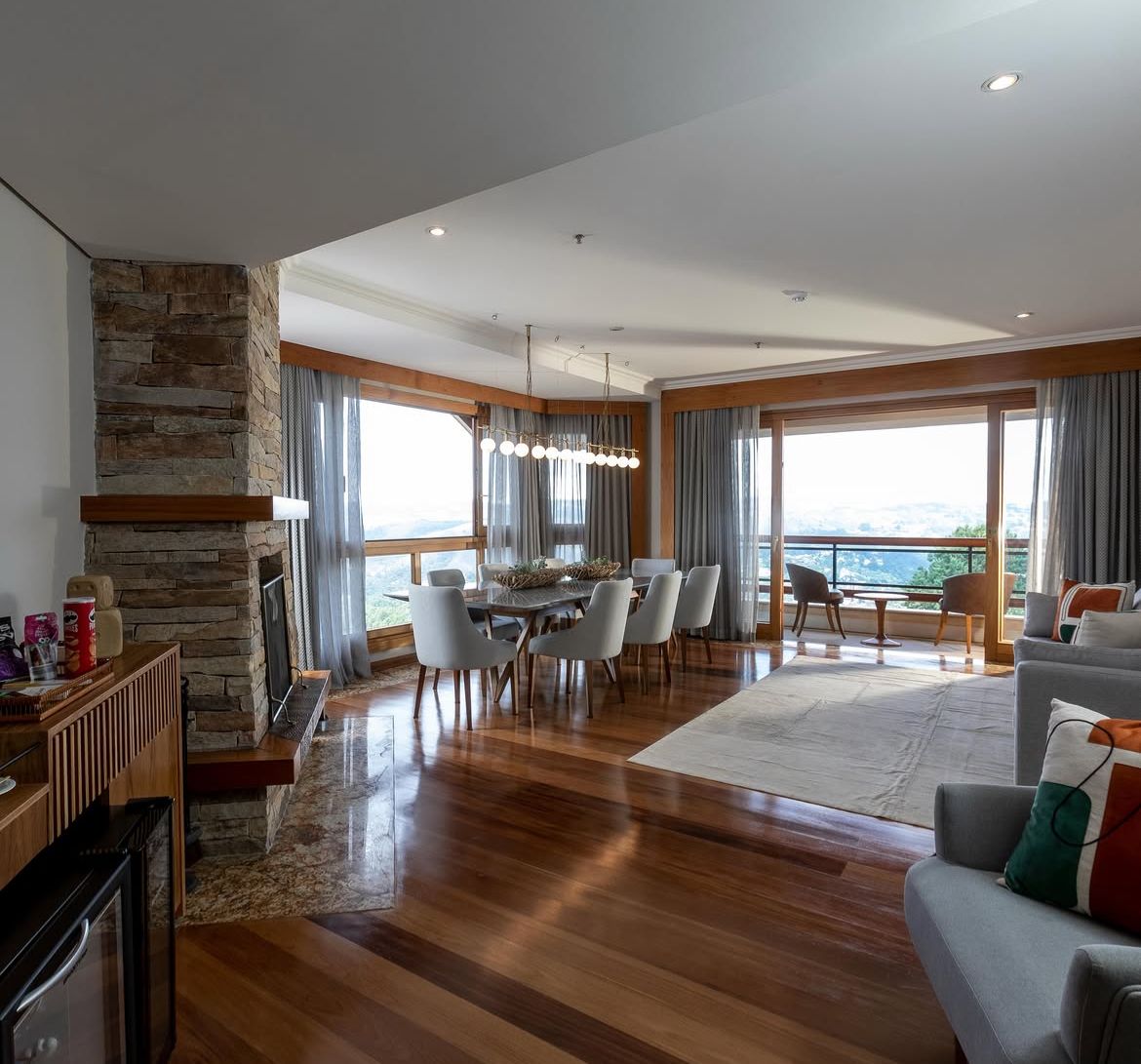 Sala de estar da suíte com lareira em pedra e vista panorâmica